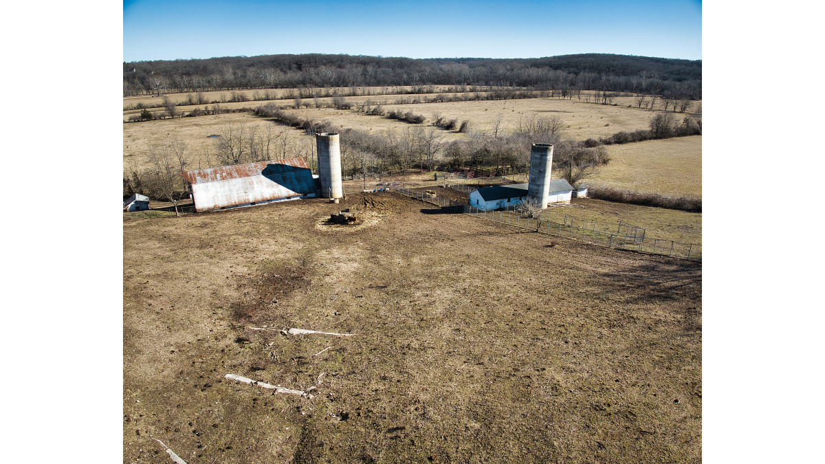 View over driveway (northwest corner) looking southeast over barns that are in good structural condition.